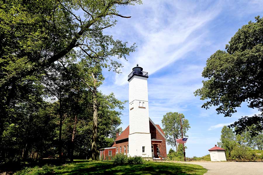 Square lighthouse and lightkeepers house among trees