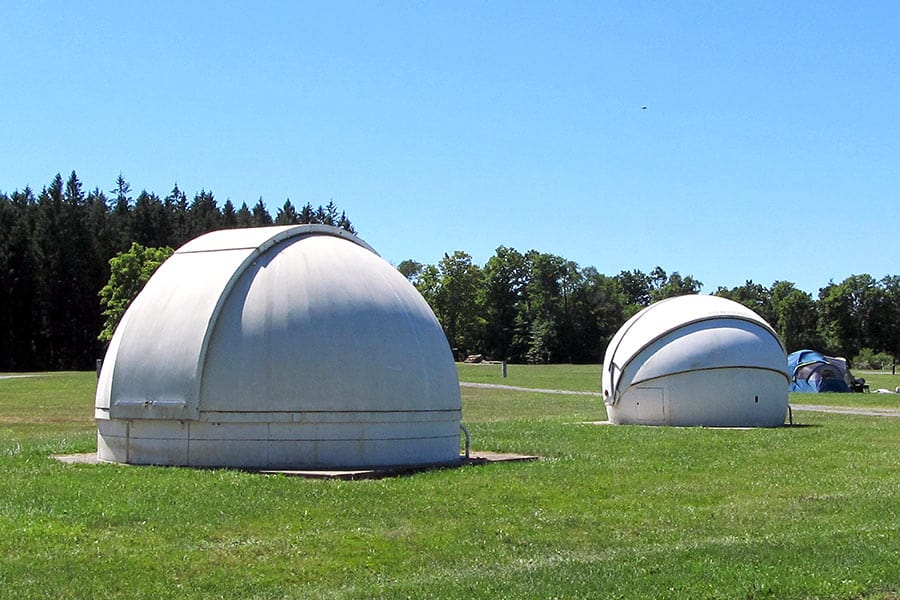 White Astro Haven observatory domes in field