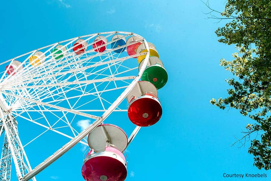 Ferris wheel with colorful seats on sunny day
