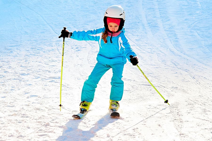 Young girl dressed in blue skiing